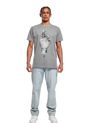 Grå bomulds t-shirt med et stort grafik af en hånd med tatoveringer i sort, placeret over bogstavet "F." Casual pasform med rund halsudskæring.