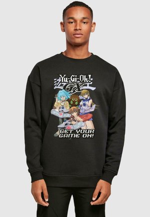 Black sweatshirt featuring a colorful graphic with anime characters from "Yu-Gi-Oh!" and the text "GET YOUR GAME ON!" in white.