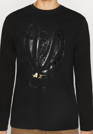 Schwarzes Langarmhemd mit einem glänzenden schwarzen abstrakten Hasengesicht-Design und goldenen "AX"-Initialen auf der Brust.