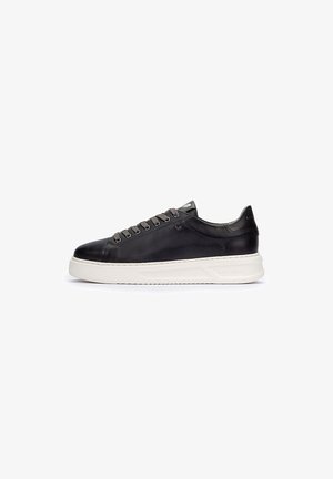 Zapatillas de cuero negro con superficie lisa, suela de goma color crema y cordones grises. Presenta un diseño minimalista y una marca sutil en el talón.