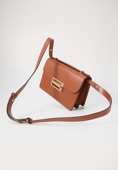 Bolso cruzado de cuero marrón con un cierre dorado, exhibido en un ángulo sobre un fondo claro, mostrando su forma y diseño.