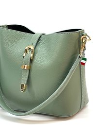 Groene gestructureerde leren schoudertas met gouden hardware, een decoratieve gesp en een kleine Italiaanse vlag charm die aan de band is bevestigd.