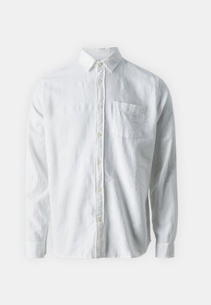 Cămașă albă cu mânecă lungă, dintr-un material respirabil, cu un guler clasic, închidere cu nasturi și un singur buzunar pe piept.