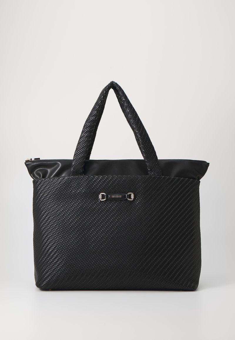 Zwarte tote bag gemaakt van gestructureerd materiaal met een gladde bovenkant, dubbele handgrepen, zilverkleurige hardware en logo-accent. Ritssluiting aan de bovenkant.
