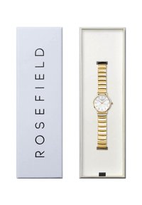 Goldfarbene Metalluhr mit einem Gliederarmbanddesign, ausgestattet mit einem weißen Zifferblatt und goldenen Akzenten, präsentiert in einer weißen Box mit schwarzem Text.