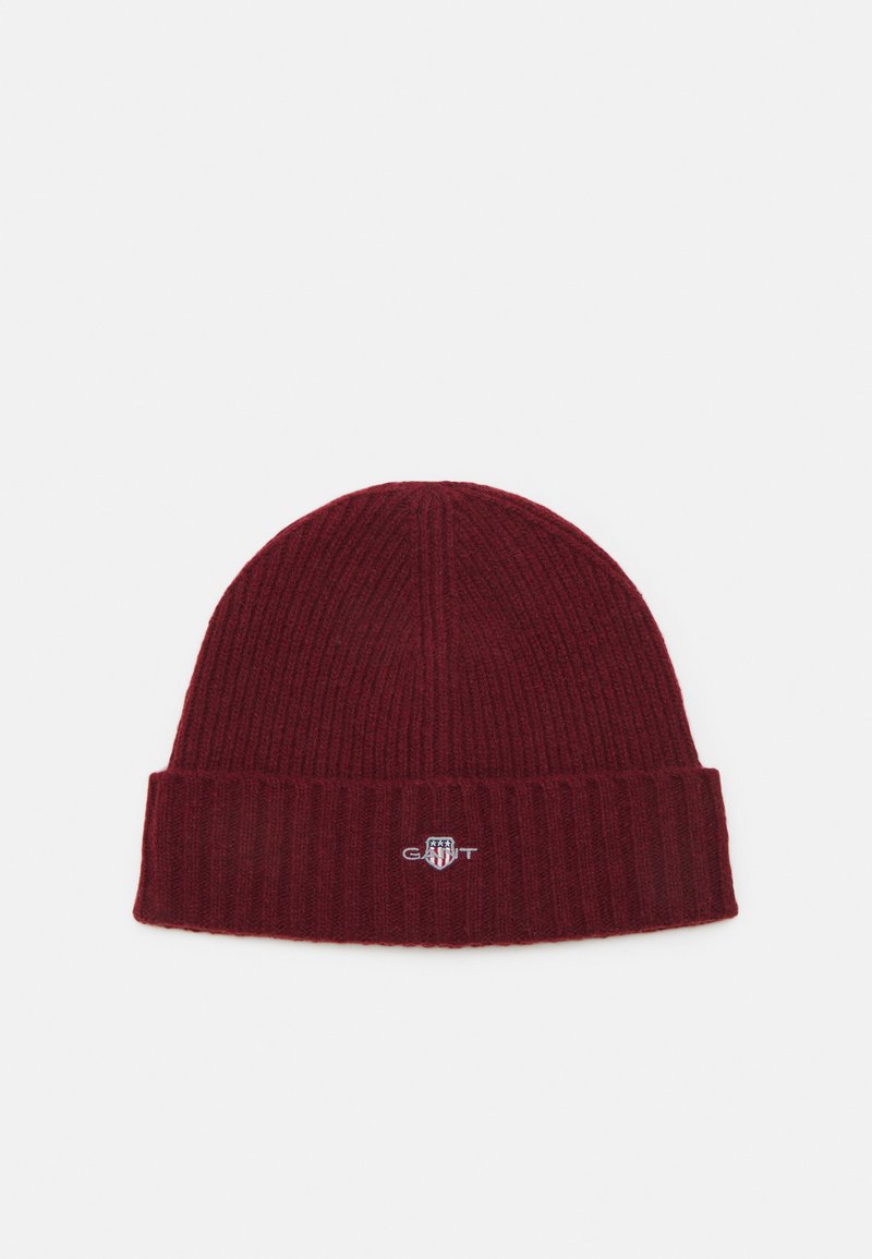 Bordeaux gebreide beanie met een geribbelde textuur en een omgevouwen rand. Bevat een klein, geborduurd logo aan de voorkant. Zacht materiaal.