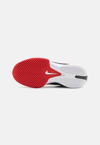 Sko sål med et rødt og hvidt gummidesign, der har strukturerede skridsikre mønstre og et fremtrædende sort og hvidt Nike-logo.