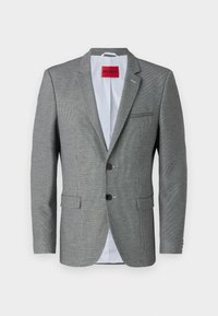 Grå mønstrete blazer med notched lapel, to knapper og to frontlommer. Fôret med lyseblått stoff og har et rødt merkeinnslag inni.
