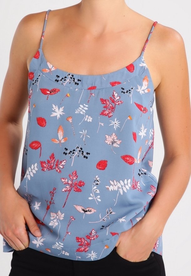 Ärmlös blå blus med blommönster som har olika röda och vita bladmönster. Tillverkad av ett mjukt tyg med spagettiband.