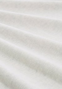 Weißer Stoff mit subtiler Textur und weichem, glattem Finish, der sanfte Falten und ein einheitliches Erscheinungsbild über die gesamte Oberfläche aufweist.