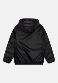 Chaqueta ligera negra con capucha, que presenta una textura suave y brillante, puños elásticos y un dobladillo fruncido para un ajuste ceñido.