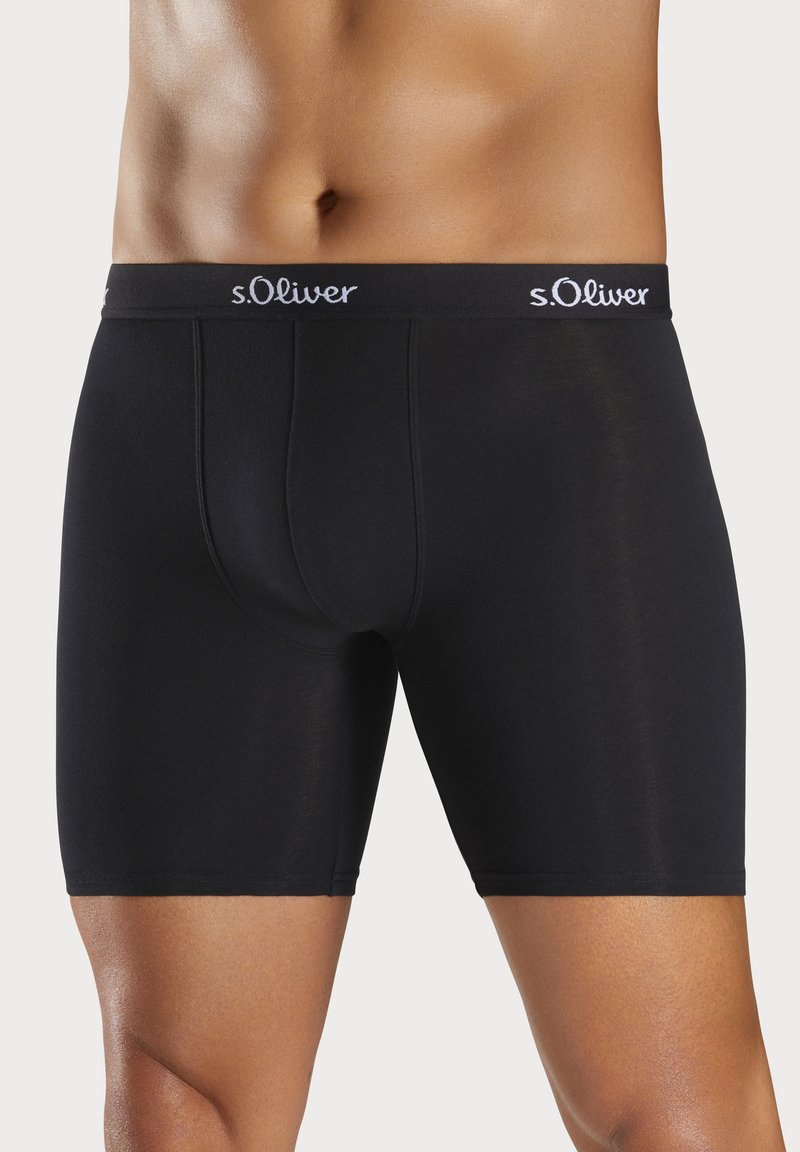 Black boxer shorts made of soft, stretchy fabric. Features a logoed elastic waistband and a fitted cut, designed for comfort and support.