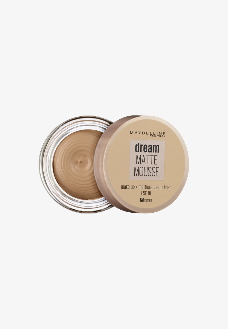 Maybelline Dream Matte Mousse in a round, clear glass container with a beige lid. The primer is a light beige color with a smooth, creamy texture.