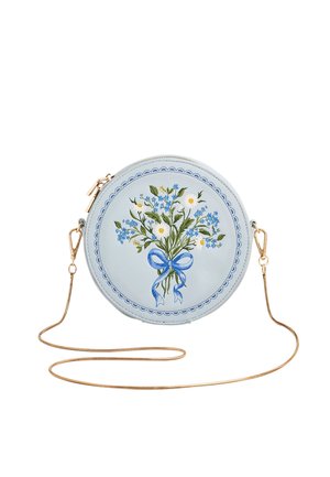 Ronde lichtblauwe tas met blauw-witte bloemen, vastgebonden met een blauw lint, gouden kettinghengsel en een rand met gegolfde details.