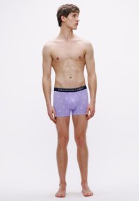 Lila boxeralsó fekete derékrésszel, amelyen a "POLO RALPH LAUREN" felirat látható. Finom mintázatként fehér ló logók vannak mindenütt.