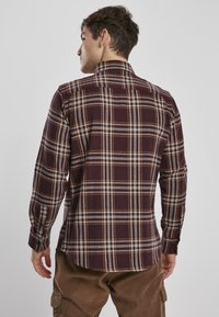 Maron rutete flanel skjorte med knapper-ner krage, med hvite og gule striper. Laget av bomull med lange ermer og mansjettknapper.