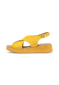 Gelbe Wildleder-Wedgesandalen mit einem Kreuzriemendesign, einem verstellbaren Knöchelriemen und einer strukturierten Plateausohle.