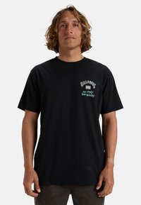 Black cotton t-shirt featuring a colored graphic and text design on the chest. Short sleeves and a relaxed fit.