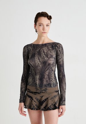 Long-sleeve top in dark grey with leaf patterns and a fitted silhouette, paired with a brown flared skirt featuring a black tie-dye pattern.