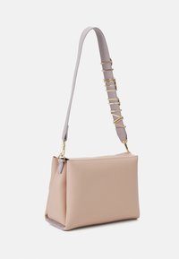 Torba ze skóry w kolorze brzoskwiniowym o uporządkowanym kształcie, z fioletowym paskiem ozdobionym złotymi elementami. Gładka tekstura, prosty design, bez widocznych wzorów.