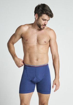 Marineblå bomuldsboxershorts med en tætsiddende design, der har en kontrastfarvet elastisk talje med røde og hvide striber samt en forstærket bærestykke.