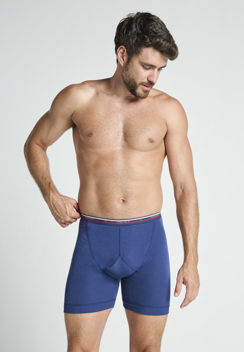 Boxers de algodón azul marino con un diseño ajustado, que cuentan con una cinturilla elástica contrastante con rayas rojas y blancas y un bolsillo reforzado.