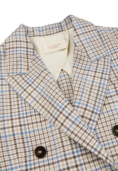 Beige blazer met dubbele rij knopen en een bruin-blauw ruitpatroon, met opstaande revers, donkere knopen en een SLOWEAR merklabel aan de binnenkant van de kraag.