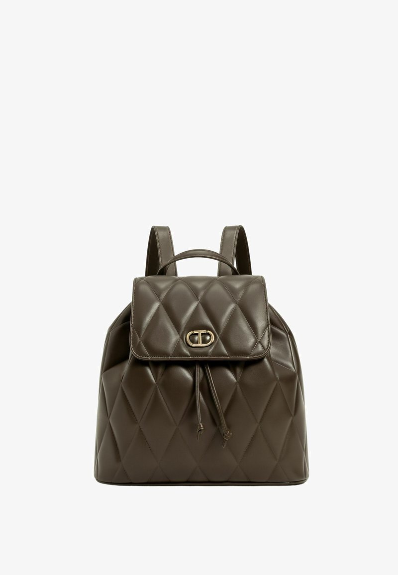 Zaino in pelle marrone trapuntata con chiusura a pattina e cordoncino. Presenta un logo metallico decorativo e spallacci doppi.
