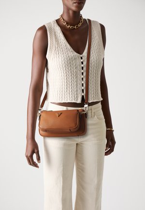 Brun skinncrossbody-veske med teksturert finish, som har klaff, sølvfarge hardware og et logo-detalj på forsiden.