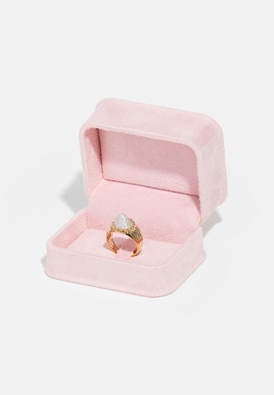 Gold ring with a textured triangular silver top, presented in a pink padded jewelry box lined with soft fabric.