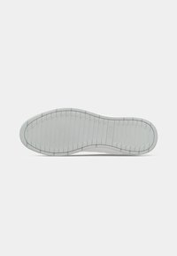 Semelle de chaussure avec un motif de bande de roulement nervuré de couleur claire et des bords arrondis, présentée sur un fond blanc uni.