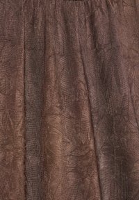 Rjava teksturirana tkanina z vidnimi navpičnimi gubami in subtilnim leskom, ki ustvarja bogat, otipljiv površinski vzorec.