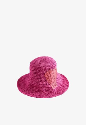 Chapeau bob rose en crochet avec un large bord et un petit patch rose tissé sur le côté.