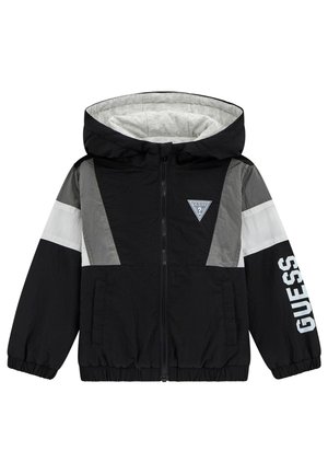 Giacca a vento nera e grigia con cappuccio, chiusura a zip, polsini elastici e un logo bianco sulla manica. Presenta un design a blocchi di colore.