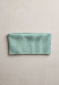 Mint green ribbed knit headband made from soft material, featuring a wide design with a textured surface and smooth edges.