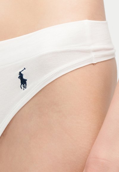 Λευκά βαμβακερά εσώρουχα στη λεκάνη ενός ατόμου με ένα μικρό κέντημα λογότυπο παίκτη πόλο σε σκούρο μπλε κοντά στη μέση.