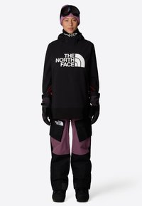 Svart huvtröja med vitt logotyp, tillsammans med svarta och vinröda snöbyxor med cargo fickor. Vantar och skidglasögon ingår.