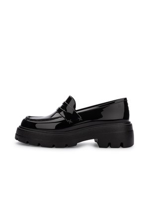 Mocasines de charol negro con una suela gruesa y texturizada, con una silueta estructurada y una tira decorativa en la parte superior.