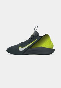 Nike atletisk sko, mørkegrå mesh overdel, buet neongrøn hæl, hvid swoosh-logo, slankt design, tekstureret overflade, snørebåndslukning.
