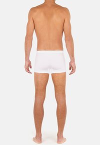 Vita bomullsboxershorts med en slät elastisk midjeband, åtsittande design och en klippning mitt på låret, som visar en enkel, odekorerad textur.