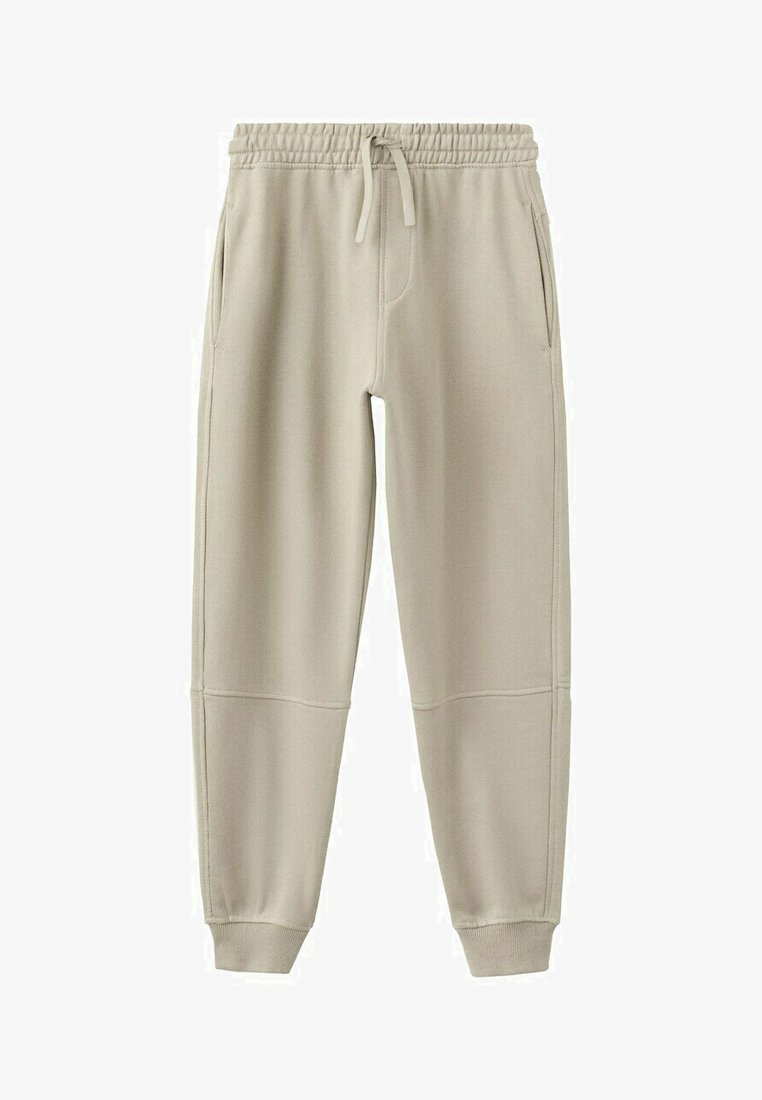 Pantalon de jogging beige avec taille élastique, cordon de serrage, poches latérales, empiècements cousus aux genoux et poignets côtelés aux chevilles.