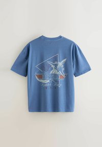 T-shirt blu con una grafica "Top Gun Fighter Town U.S.A" che mostra un aereo da combattimento e una stella all'interno di un design triangolare sul retro.