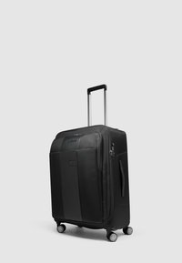 Maleta negra con ruedas, superficie texturizada, asa retráctil y ruedas multidireccionales. Cuenta con una cremallera grande y asa lateral.