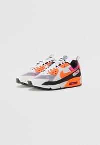 Nike Air Max -kengät valkoisella, oranssilla, violetilla ja mustalla värikuvioinnilla, pehmeällä pohjalla ja kuvioidulla verkko-yläosalla.