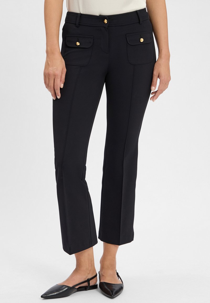 Schwarze maßgeschneiderte Hose mit glatter Textur, ausgestattet mit zwei Vordertaschen mit goldenen Knöpfen, knöchellang und mit leichtem Schlag am Saum.
