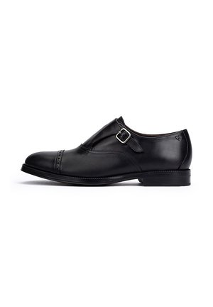Zapato formal de cuero negro con hebilla y detalles cosidos. Presenta una punta redondeada y un tacón bajo para un aspecto elegante.