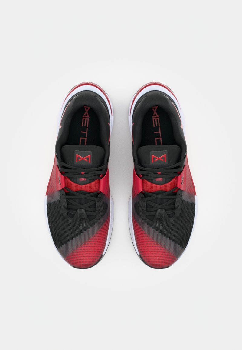 Zapatillas deportivas rojas y negras con parte superior de malla, suelas de goma lisas y acentos en contraste; presentan un patrón diagonal y cordones negros.