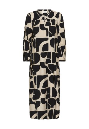 Bež dolga obleka s kratkimi rokavi, okrašena z abstraktnim vzorcem črnih geometrijskih oblik, okrogel izrez in rahli gubi pod ramenom.