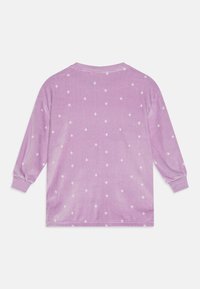 Langermet topp i myk lilla stoff med et hvitt diamantmønster. Rund halslinning og ribbestrikkede mansjetter fullfører designet.