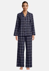 Marinblå rutiga pyjamasset gjort av mjukt tyg. Långärmad knäppblus med snedkrage, tillsammans med löst sittande byxor med vida ben.